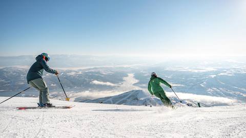 Man skiing behind Deer Valley Ski Instructor.