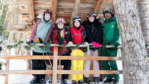 Group of teenagers smiling with a Deer Valley Ski Instructor.