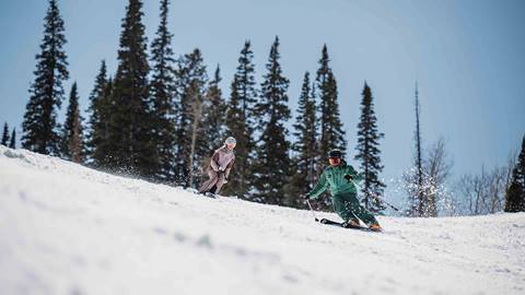 Deer Valley Ski Instructor skiing with female student in Park City, Utah.