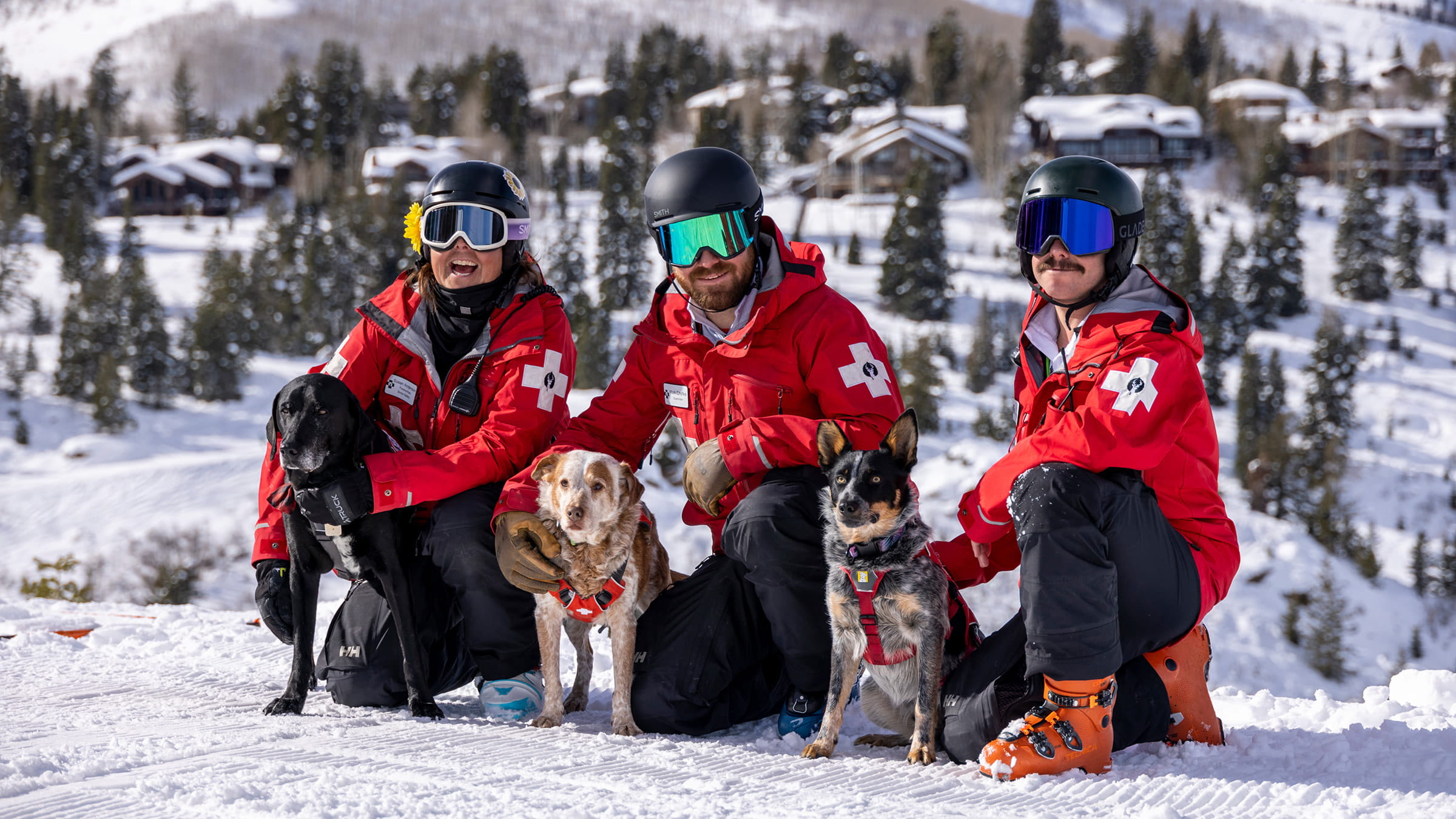 Deer Valley Ski Patrol Team smiling with the avalanche dogs