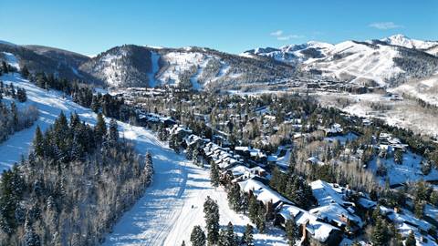 A breathtaking winter aerial view of Deer Valley, showcasing charming private homes amidst the scenic beauty.