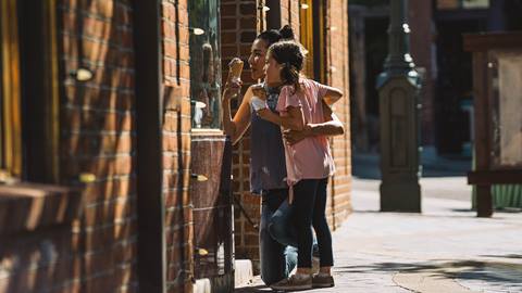 Mom and daughter eating ice cream and window shopping on Main Street in Park City.