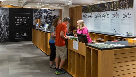 Deer Valley staff member assisting two guests at the Summer Activities Center in Snow Park Lodge.