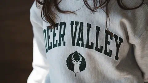 Girl wearing Deer Valley logo sweatshirt.