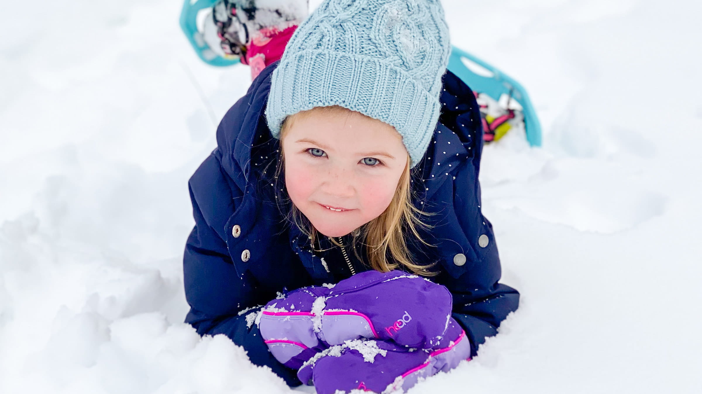 Girl smiling and playing in the snow.