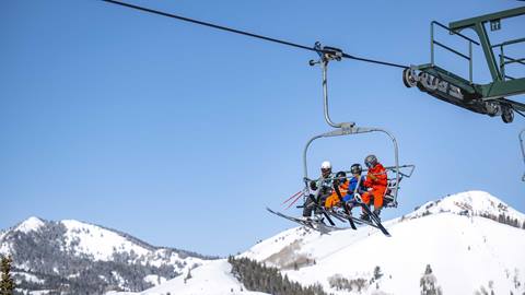 Family of four riding chairlift at Deer Valley in the winter.