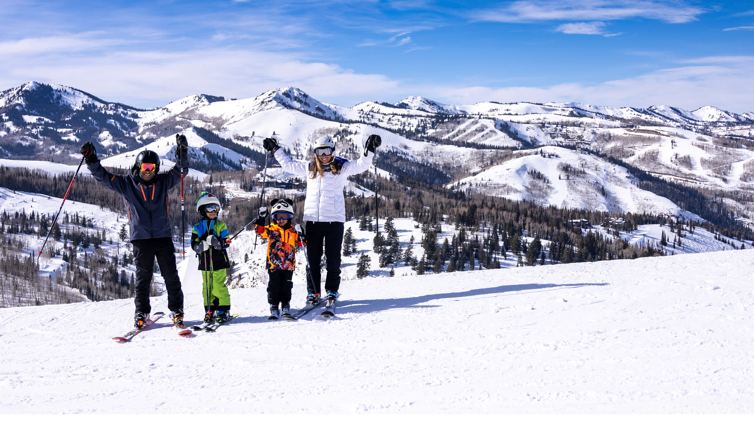 Family posing for picture wearing skis