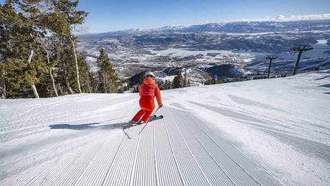Woman skiing groomed run with a view at Deer Valley.