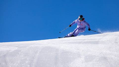 Athlete Kaylin Richardson skiing groomed run at Deer Valley on a bluebird day.