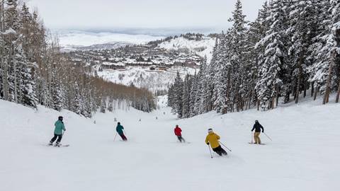 Group of guests skiing down trail at Deer Valley.