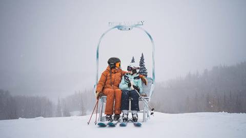 Mother and daughter sitting on chairlift art installation at Deer Valley in the winter.