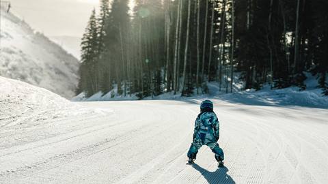 Boy skiing down groomed run at Deer Valley.