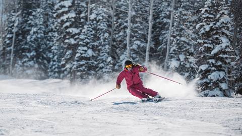 Female skier skiing at Deer Valley in pink ski gear