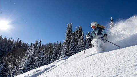 Woman power skiing on a bluebird day at Deer Valley Resort.