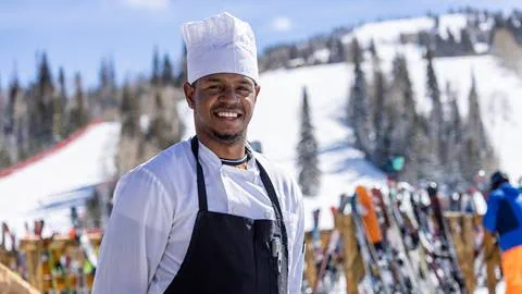 Chef smiling outside in front of ski rack