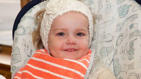 Little Girl Sitting in Height Chair