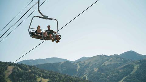 Couple on a scenic chairlift ride at Deer Valley in the summer.