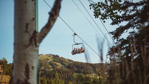 Family of four on a scenic chairlift ride in the summer at Deer Valley.