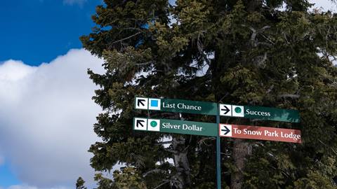 Deer Valley trail sign for Silver Dollar, Last Chance, Success ski runs, and Snow Park Lodge.