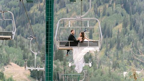 Bride and Groom on chairlift with mountain views at Deer Valley wedding