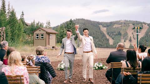 Grooms holding hands at Deer Valley's wedding ceremony venue Homestake.