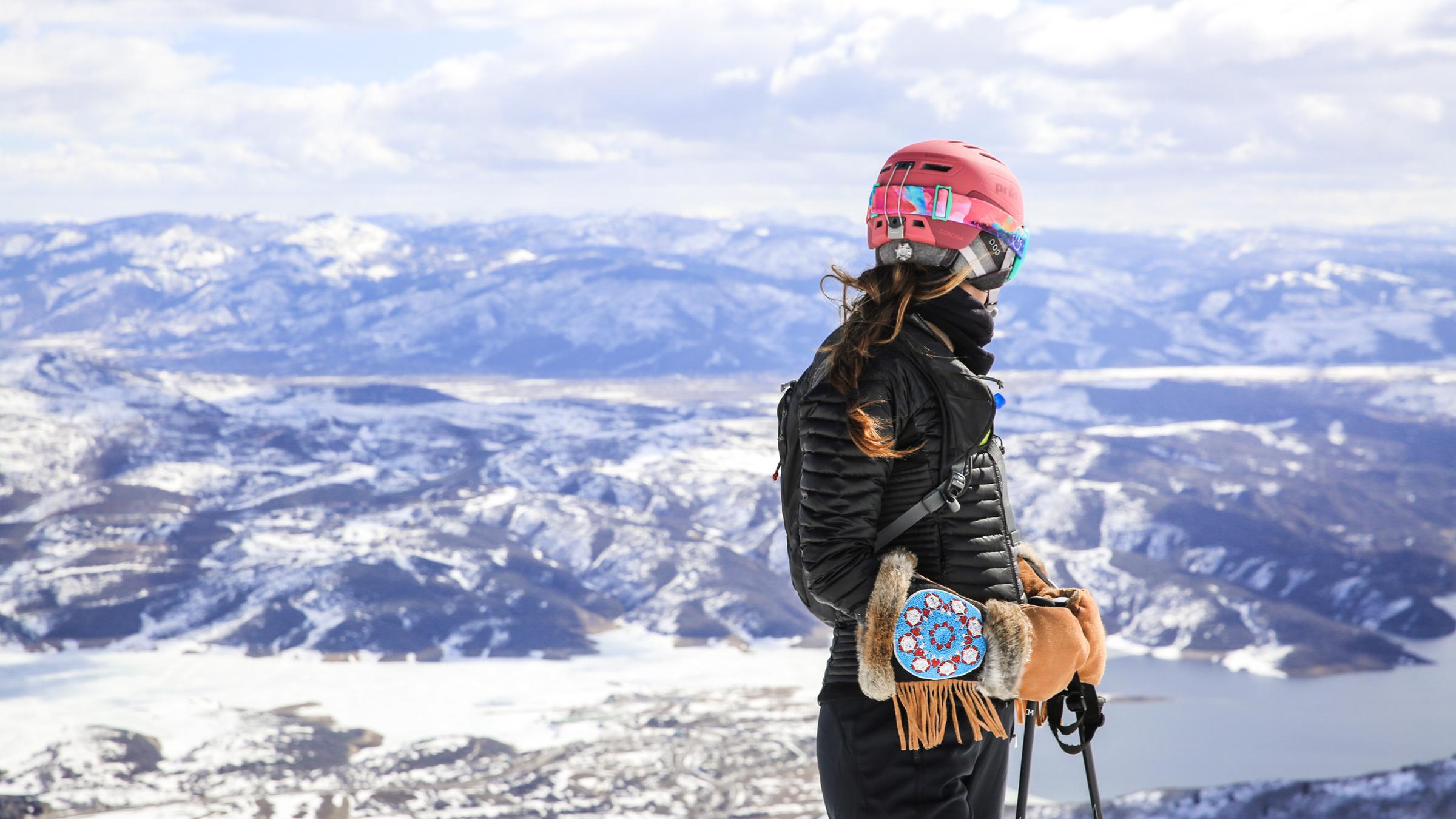 Woman standing overlooking ski run