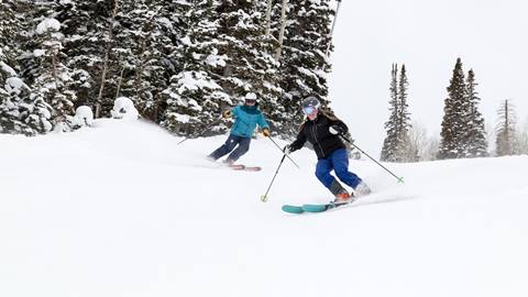 Skiers moving through powder at Deer Valley