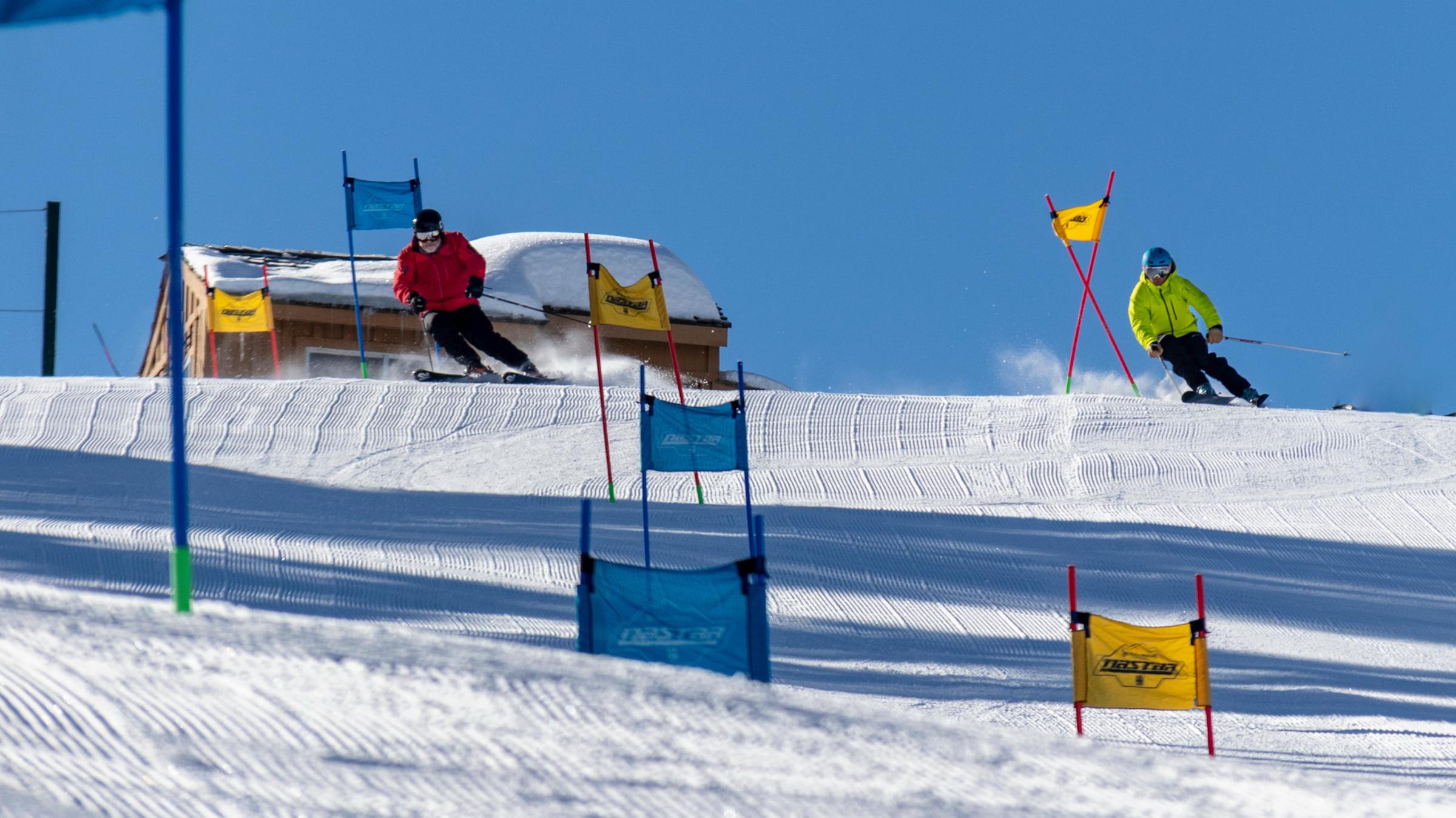 Two guests skiing the NASTAR course