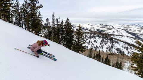 A guest skiing down a groomed run at Deer Valley Resort