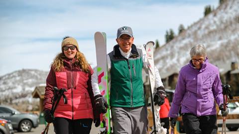 Deer Valley staff member helping guests with their skis.