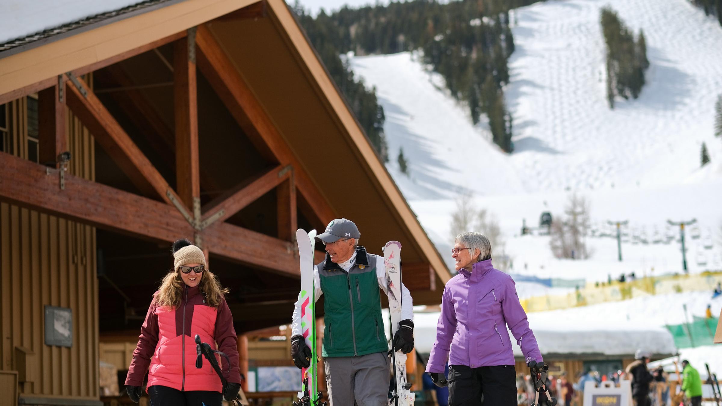A guest services attendant carrying guest skis