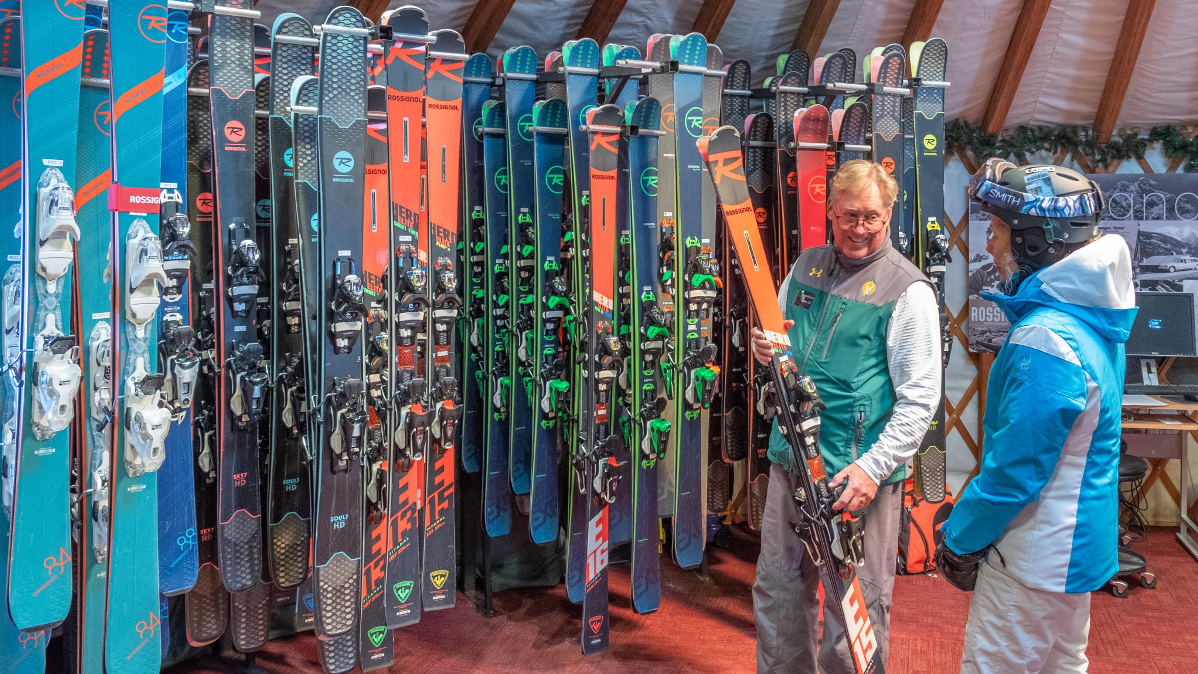 a yurt staff memeber showing a guest skis