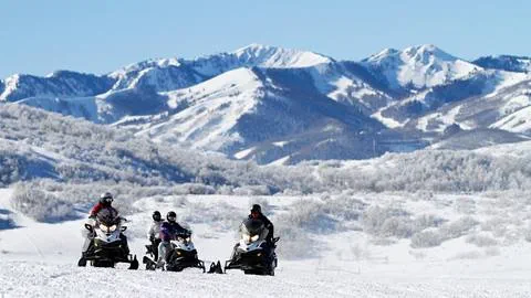 Snowmobiling with mountains in the background