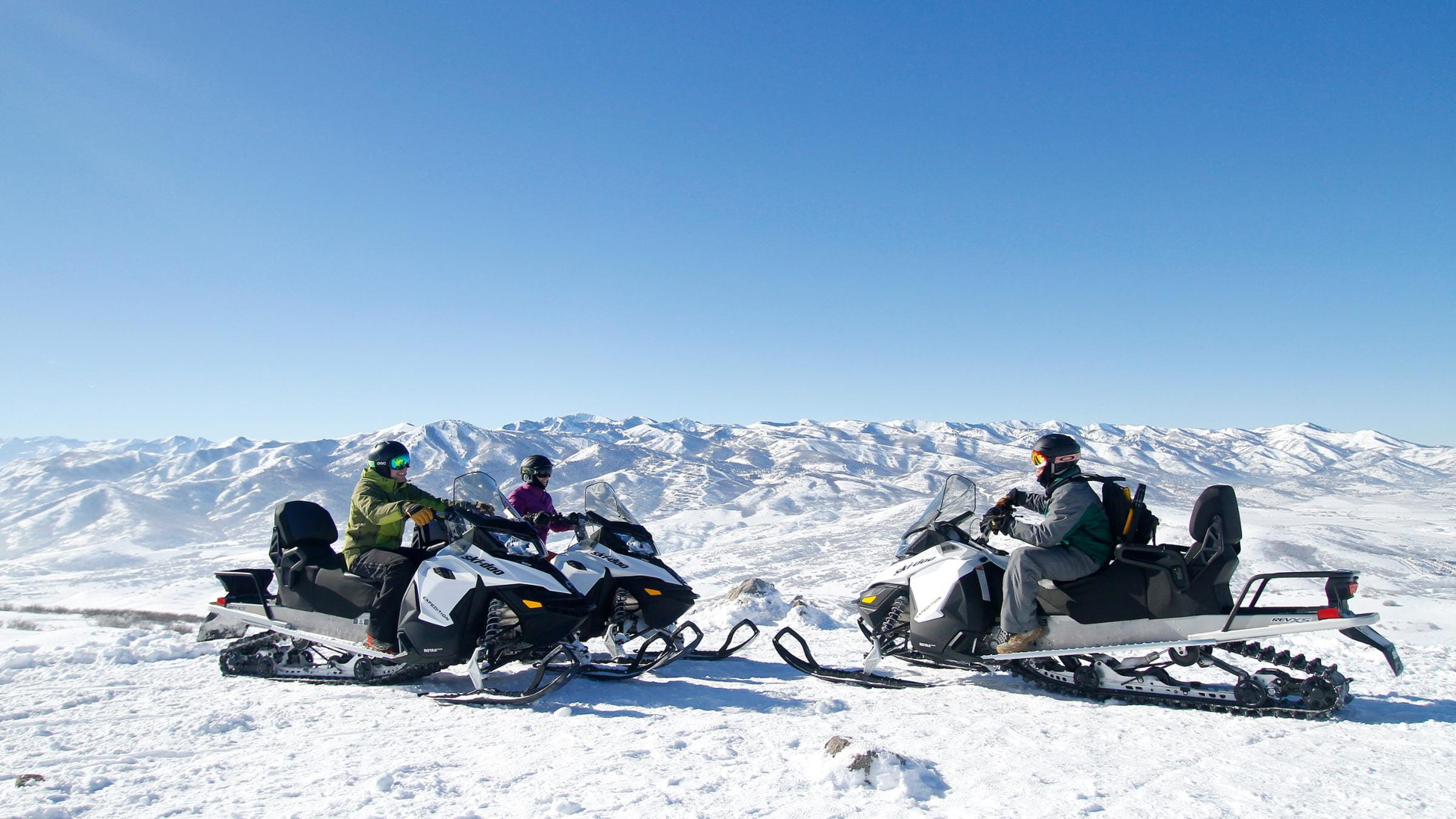 Two guests with a snowmobiling guide