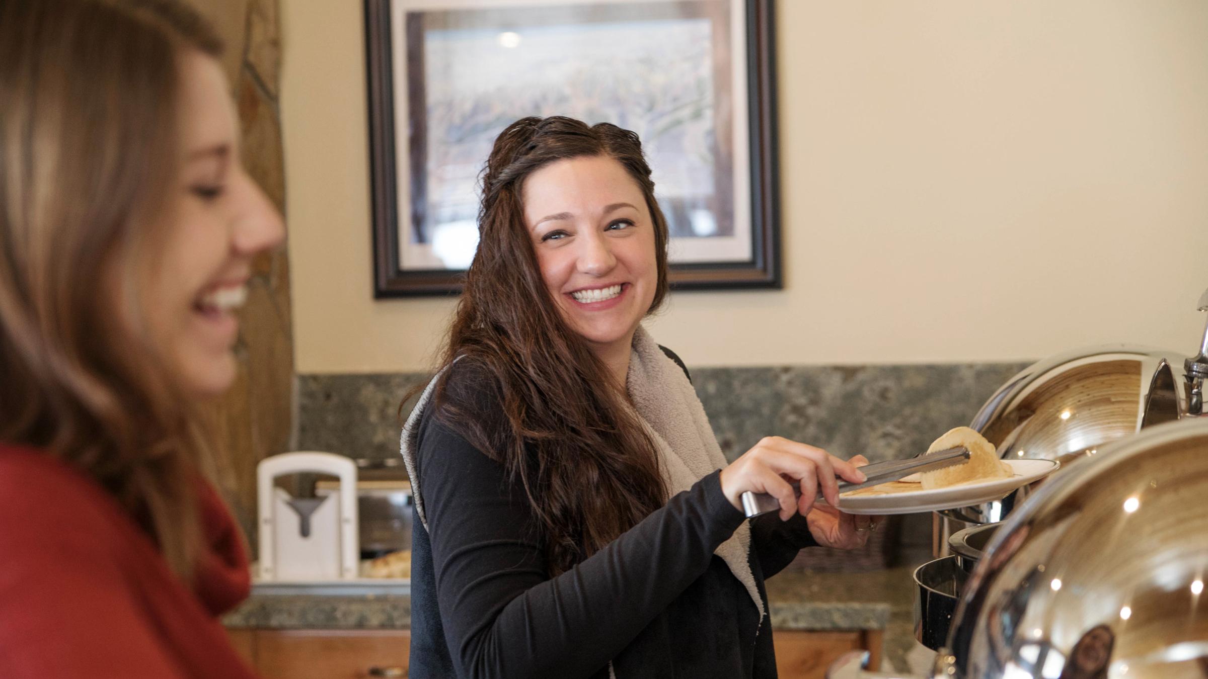 A guest smiling at the breakfast buffet at Trails End Lodge