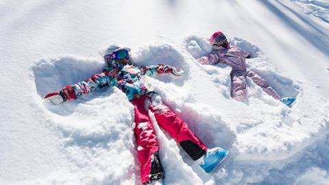 Two girls making a snow angels