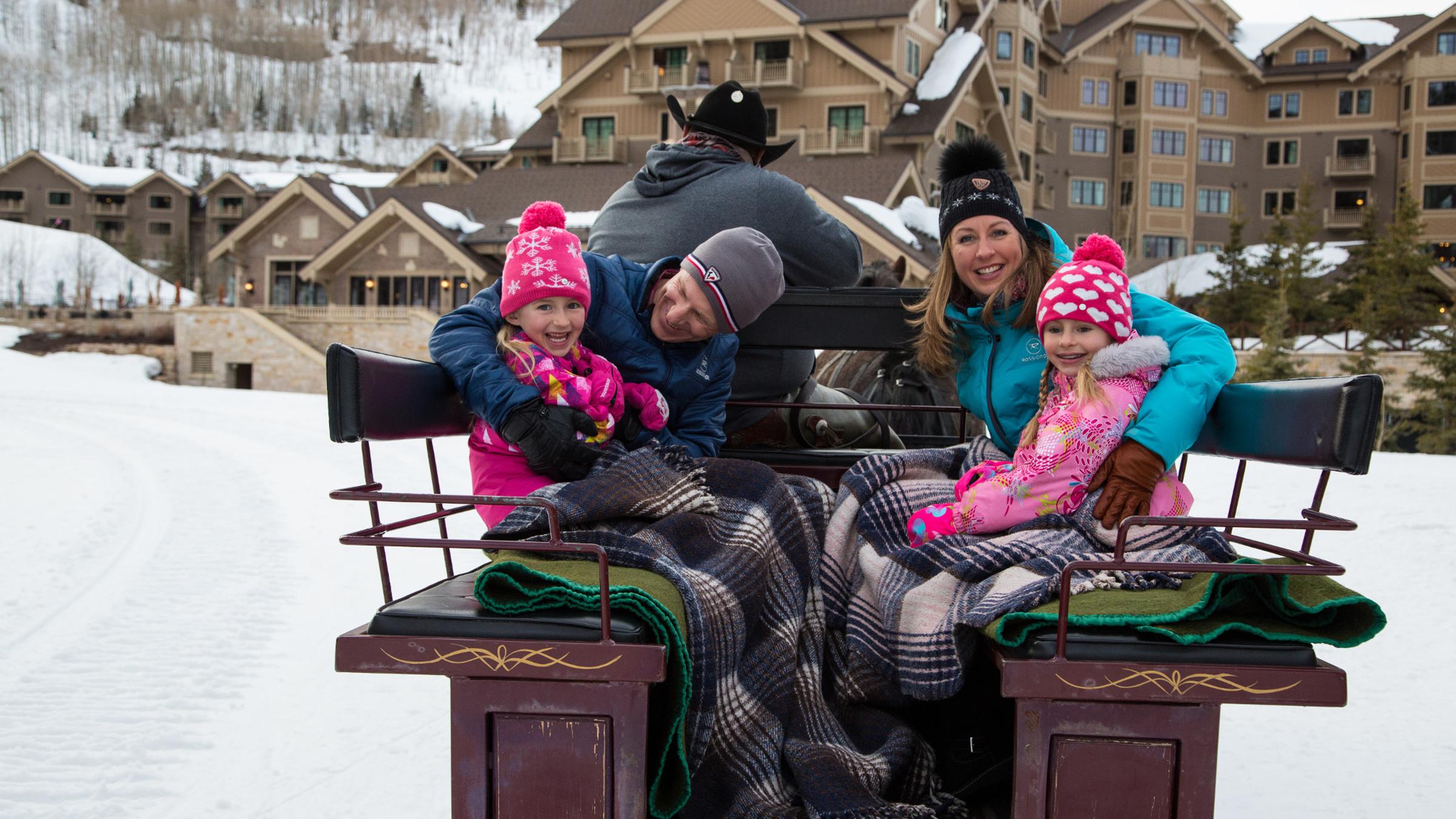 A family taking a sleigh ride to Fireside Dining