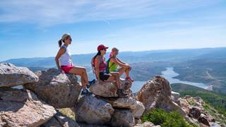 Three ladies sitting on rocks during at Hike on Blad Mountain with Jordanelle in the background