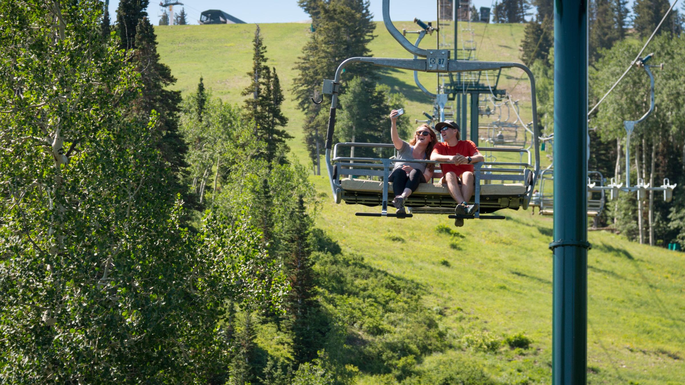 Two guests riding the chairlift down taking a selfie