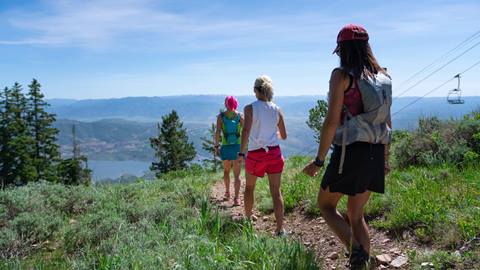 Three ladies hiking with Jordanelle and a chairlift in the background