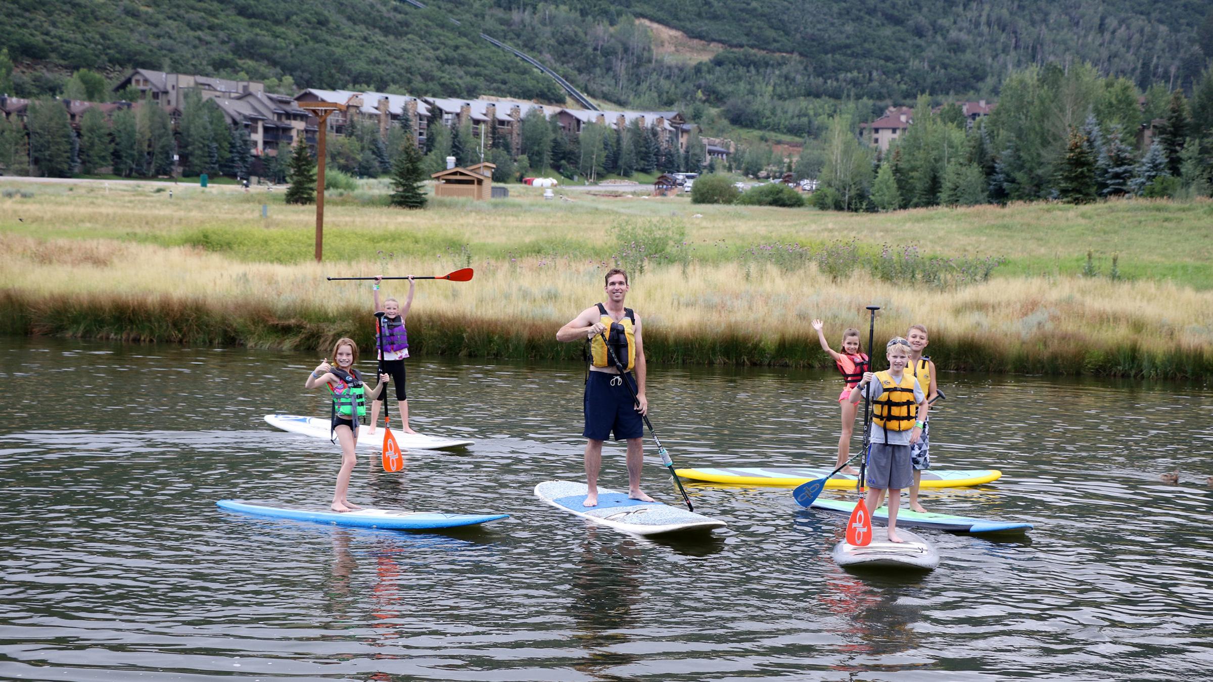 Campers standup paddleboarding at the Deer Valley ponds