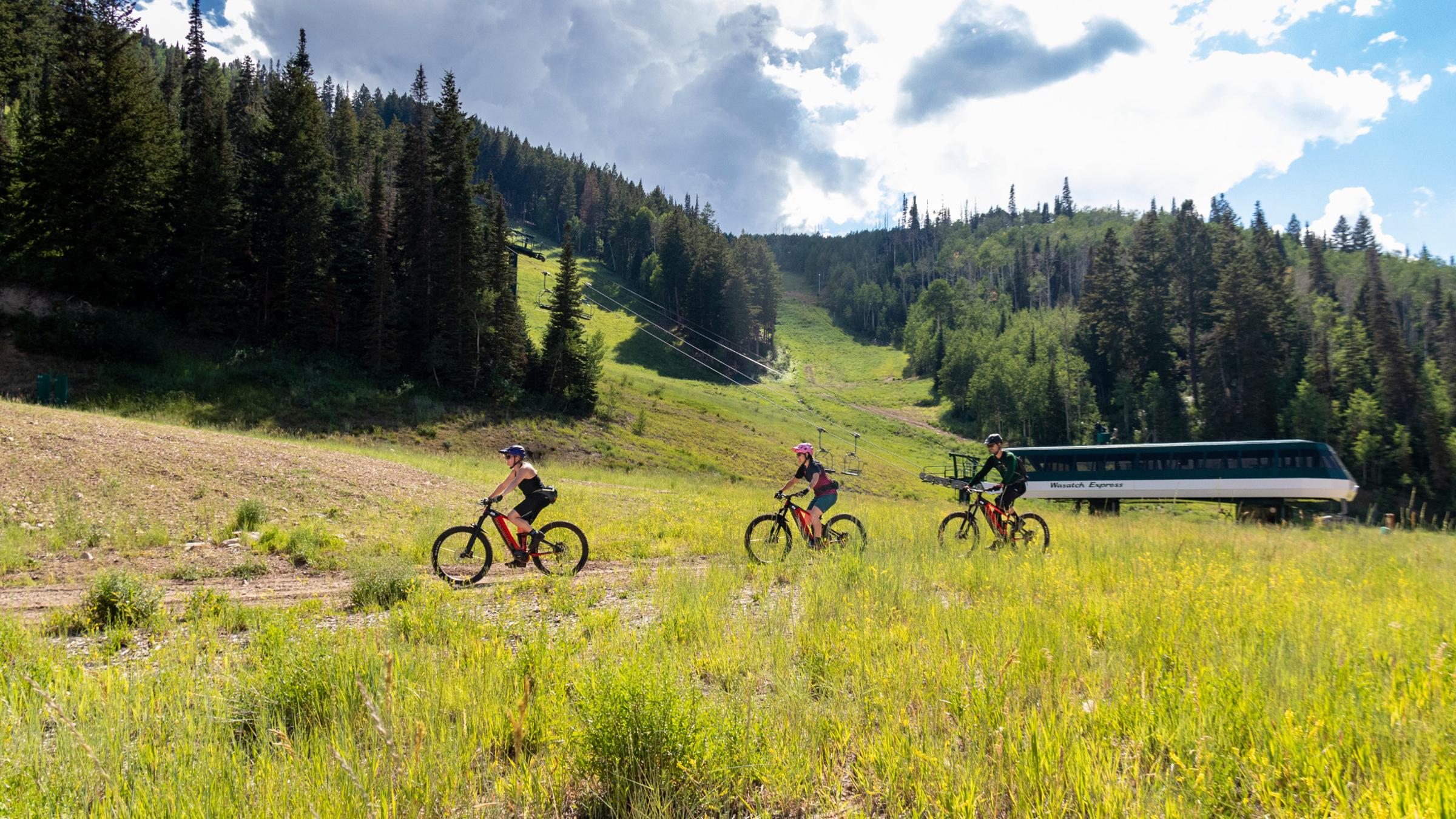 Two guests on an ebike tour at Deer Valley Resort with a Deer Valley bike guide