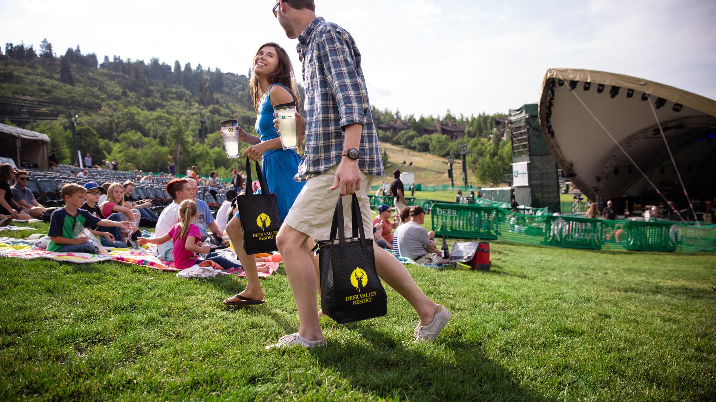 A couple carrying Deer Valley Gourmet Picnic Bags