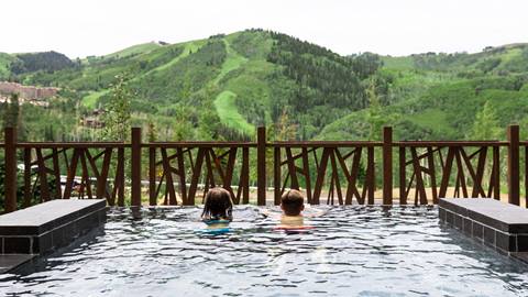 Swimmers take in view of Empire Pass at Deer Valley in Park City, Utah