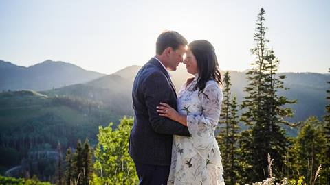 A bride and groom embracing each other on top of a mountain at Deer Valley