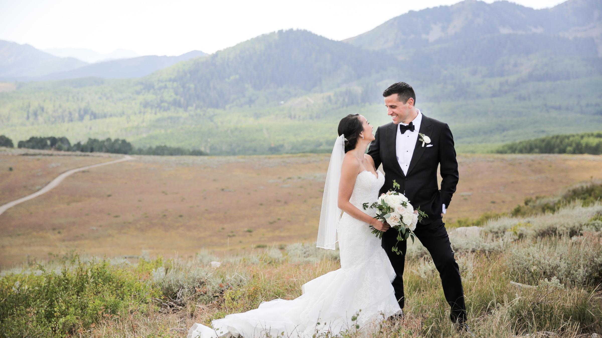 A bride and groom smiling at eachother