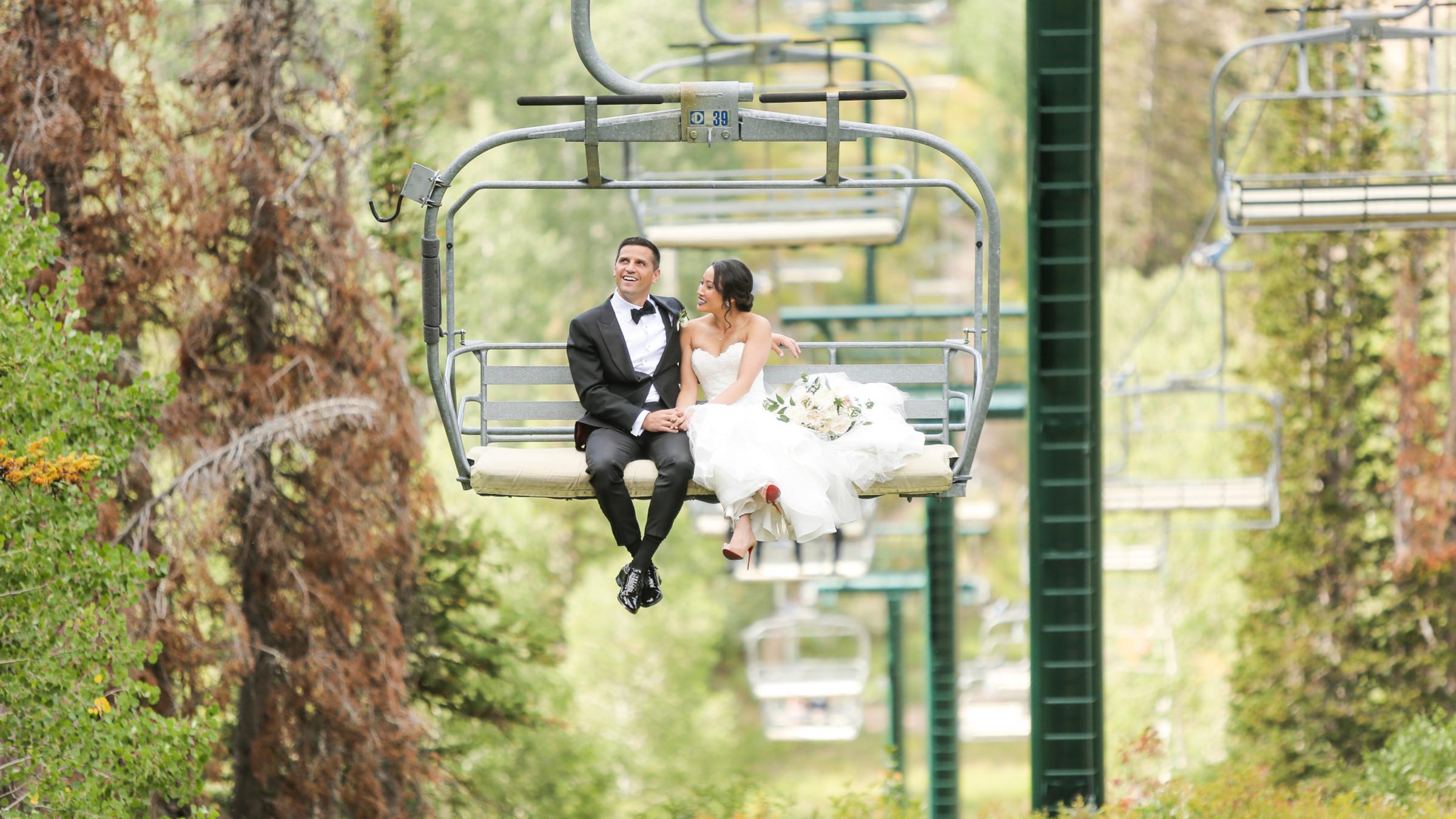 A bride and groom riding up a chairlift together at Deer Valley Resort
