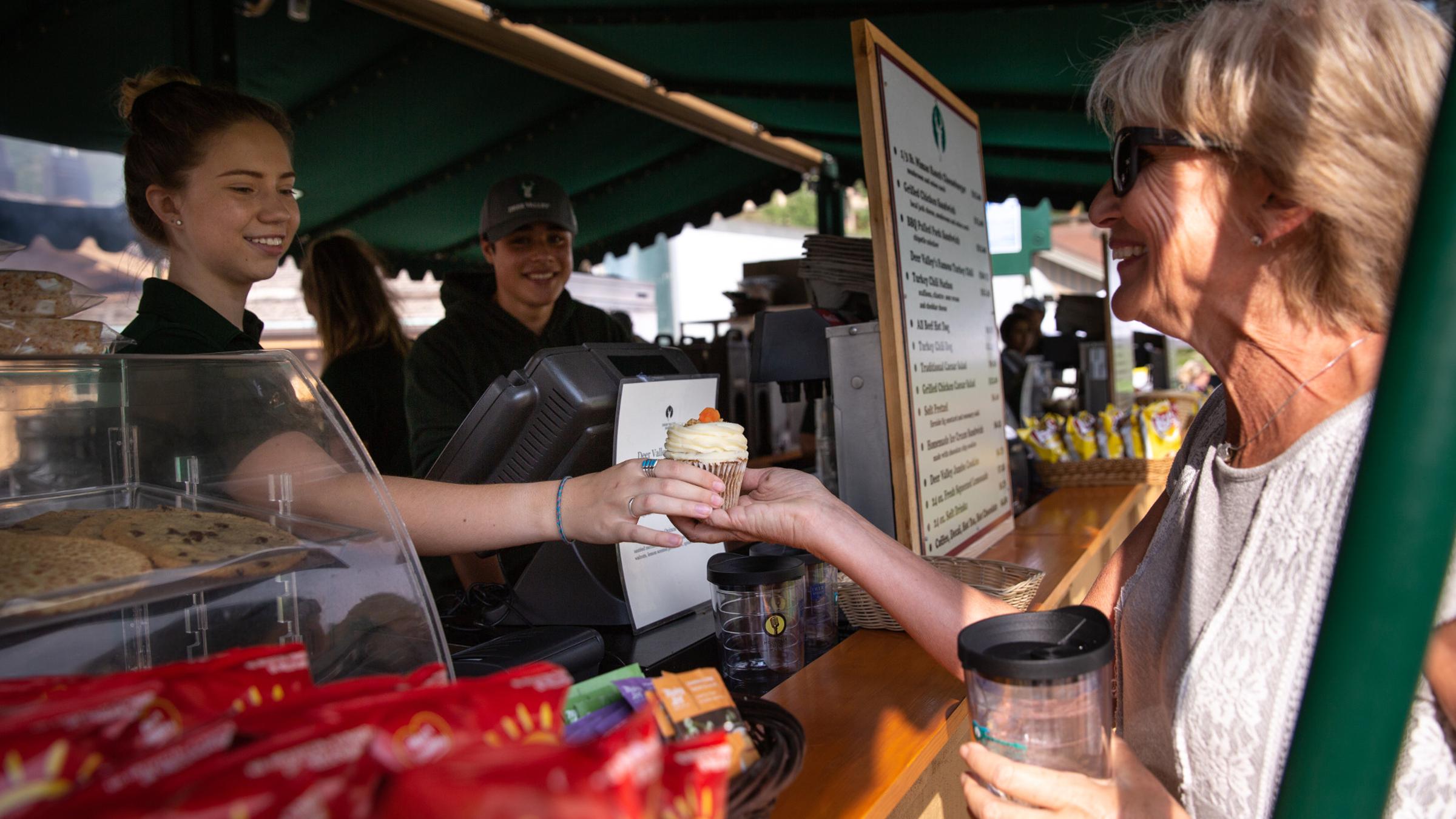 a guest receiving a cupcake at the concessions stand
