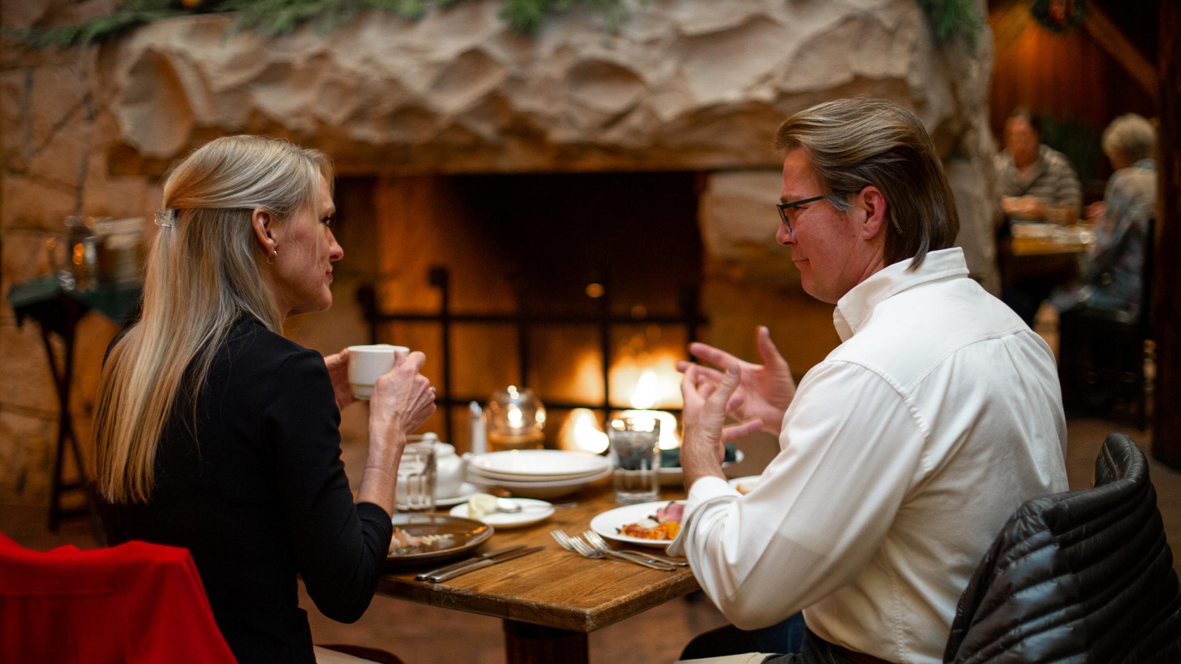 Two guests having dinner at Seafood Buffet in front of a fireplace