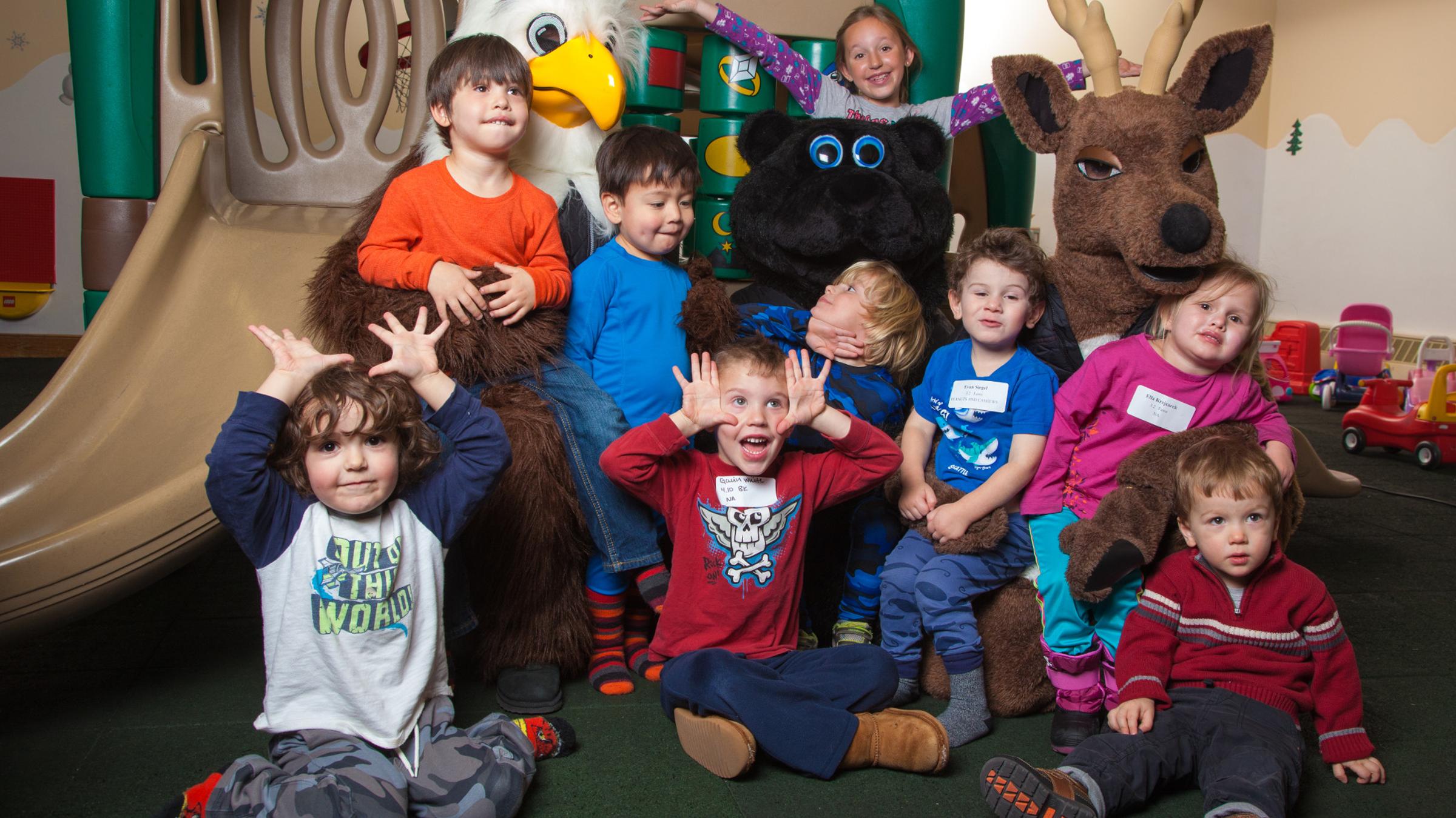 A group of children smiling and laughing with Deer Valley Mascots